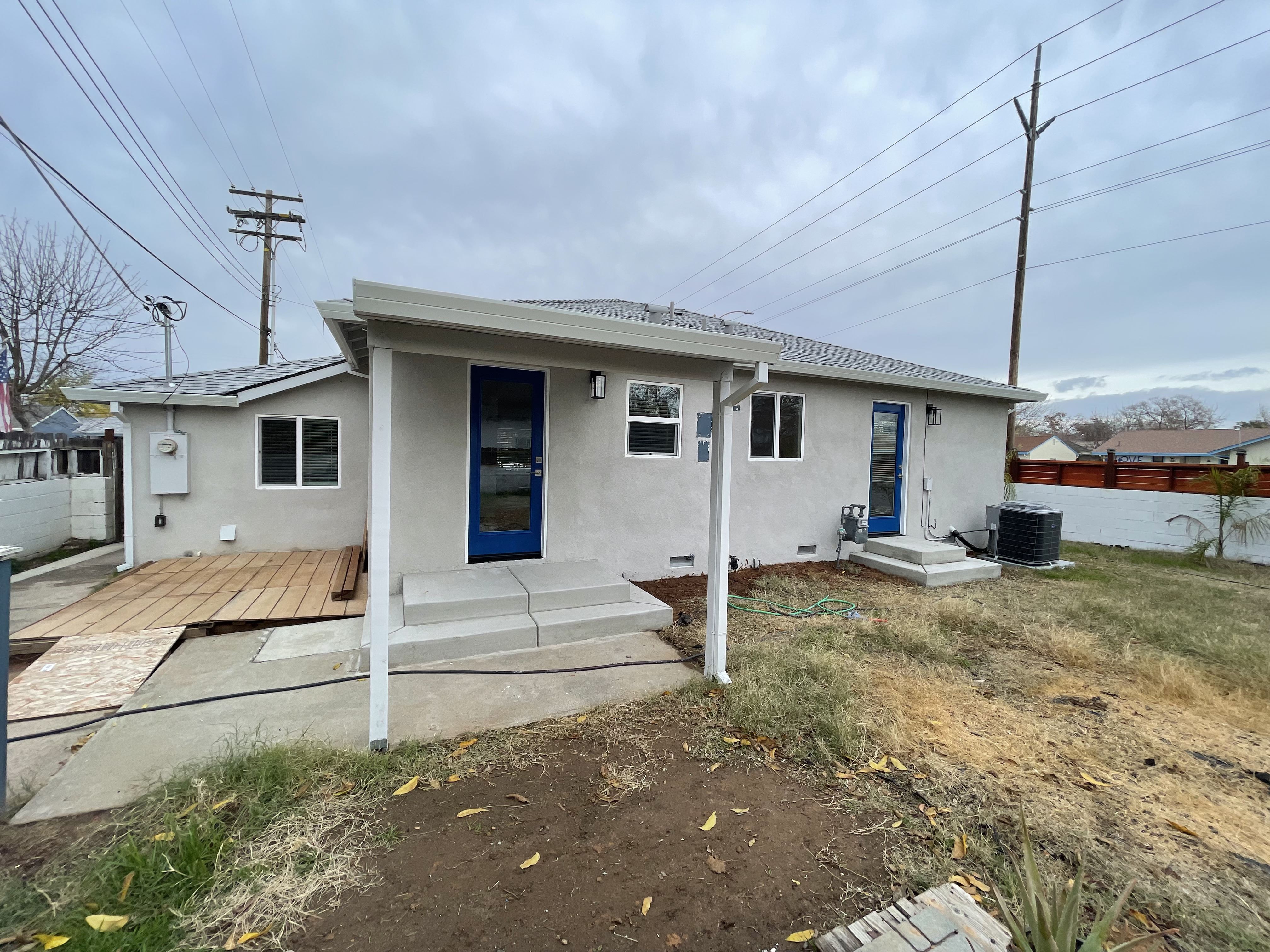 After Rear, Repaired Stucco Siding, Roof, Door, Windows and Paint. Photo